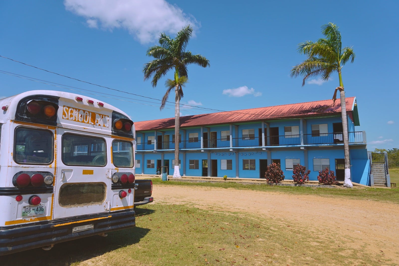 The partner school's campus building and bus in Belmopan, Belize