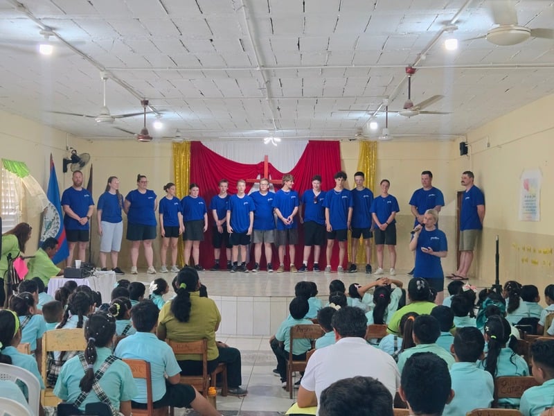 The team on stage at a school assembly