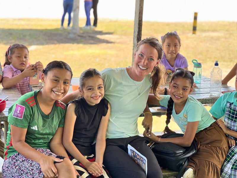 A volunteer with local girls during village outreach