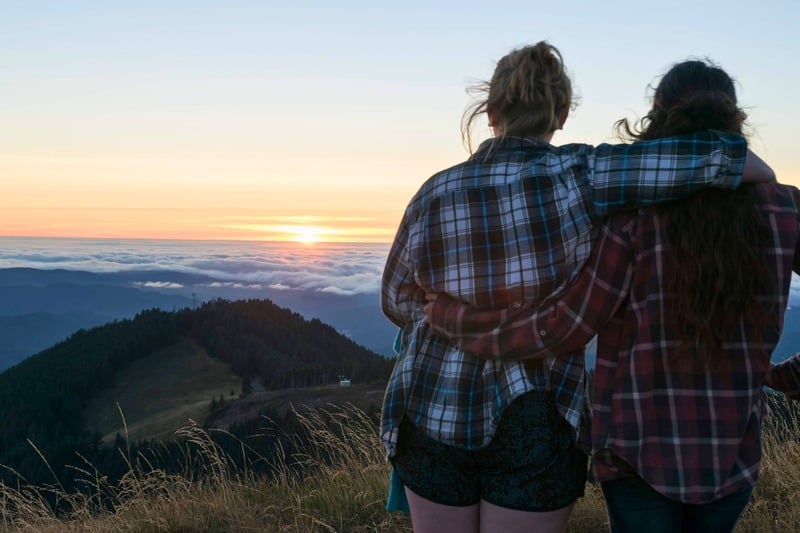 Team members watching the sunset from a mountain overlook