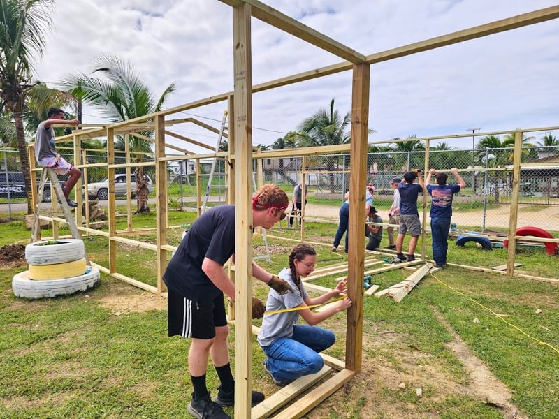 Students and team members framing a new building structure