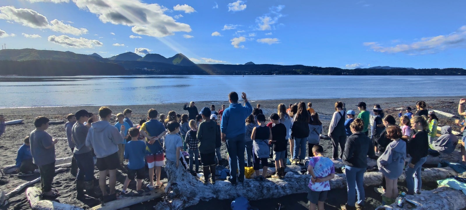 A team gathered on the beach overlooking the mountains