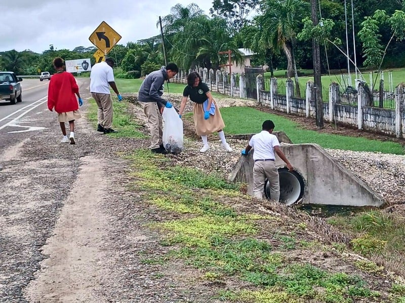 Team members cleaning up along a roadside