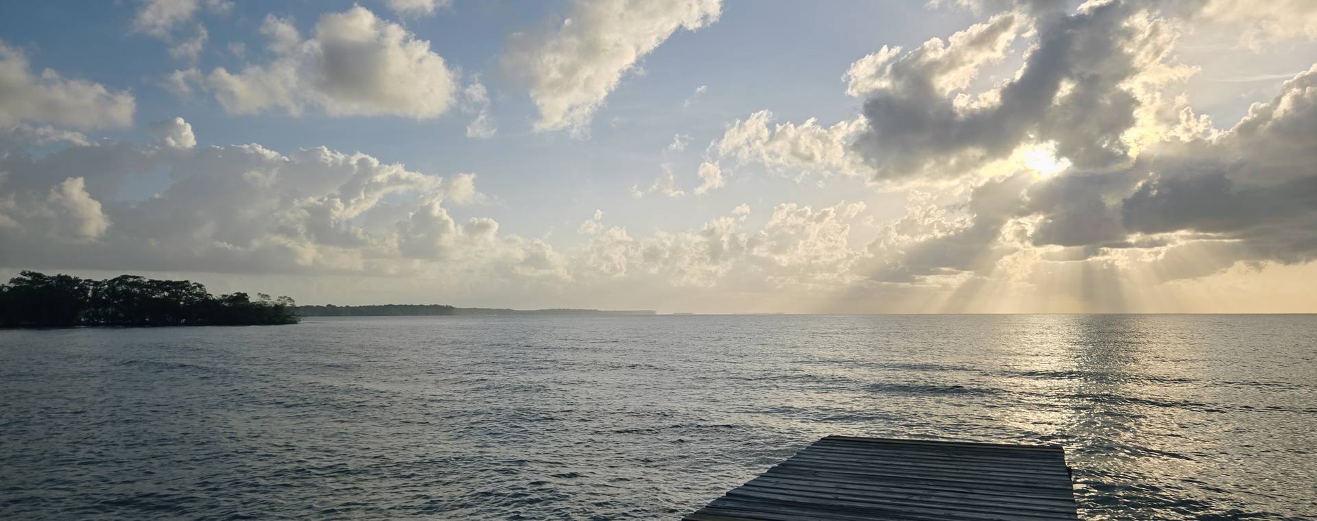 A wooden dock reaching out over calm water at sunset