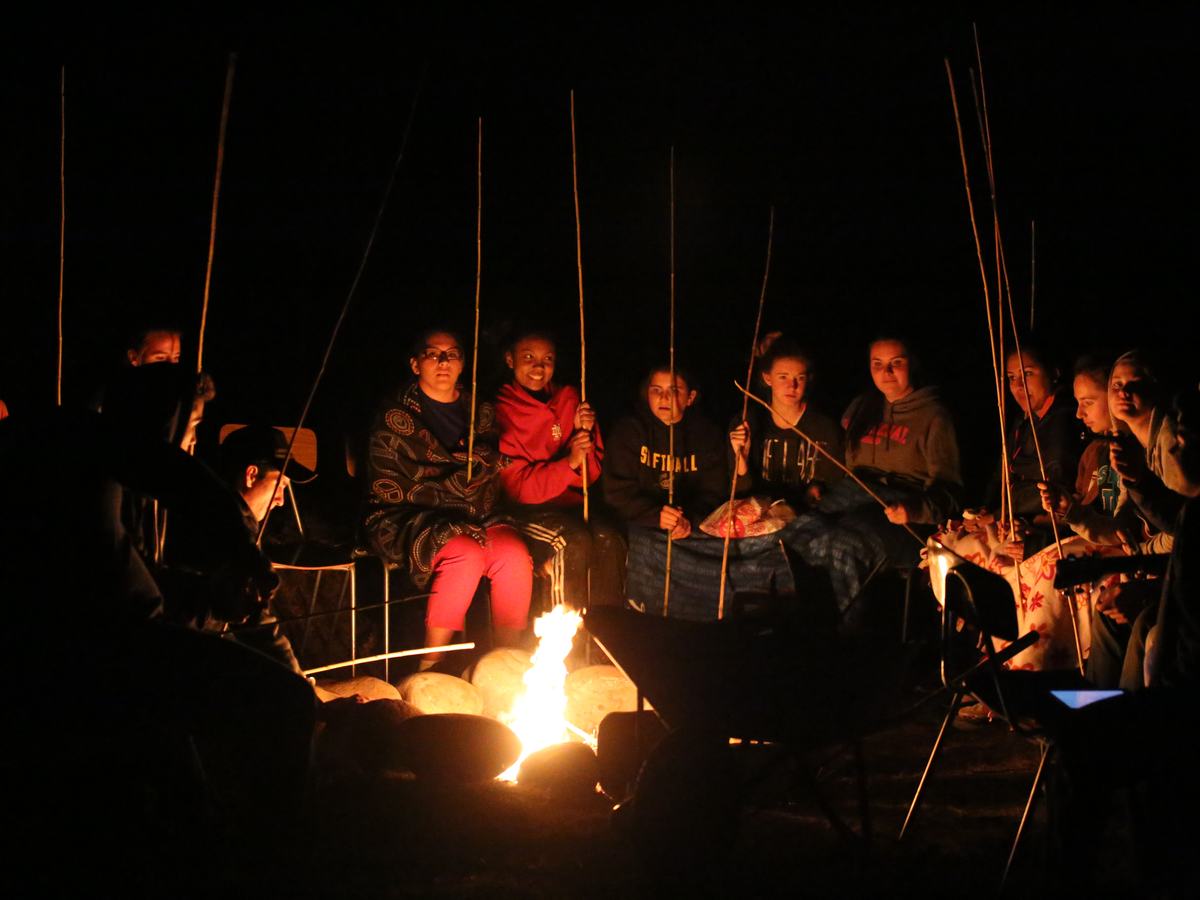 A team gathered around a campfire at night
