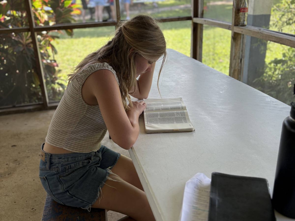 A student reading her Bible at a table