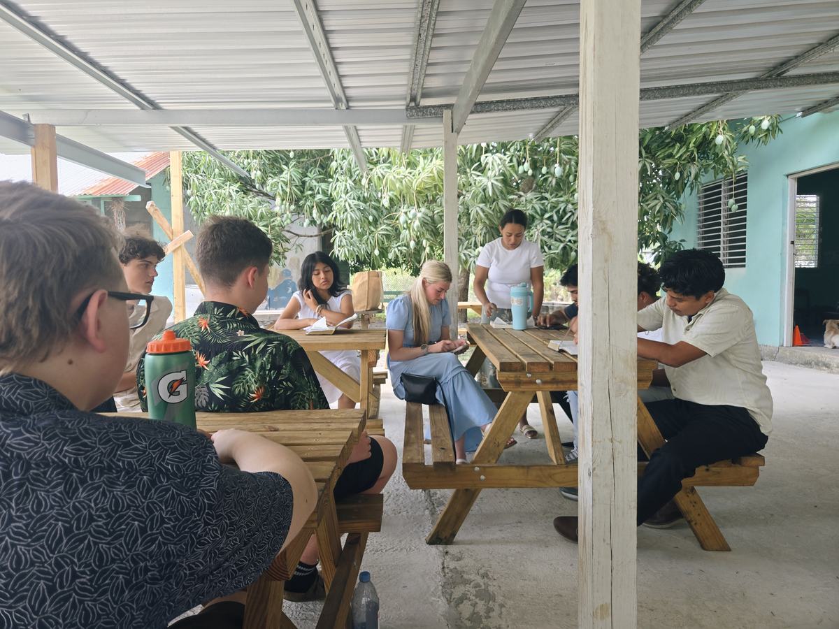 Students journaling together at outdoor picnic tables