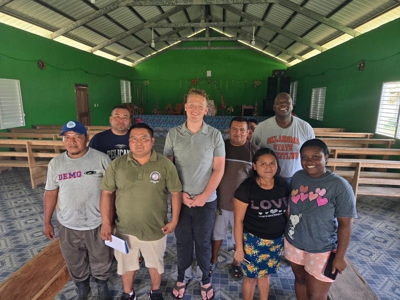 The team gathered with community members in the village hall